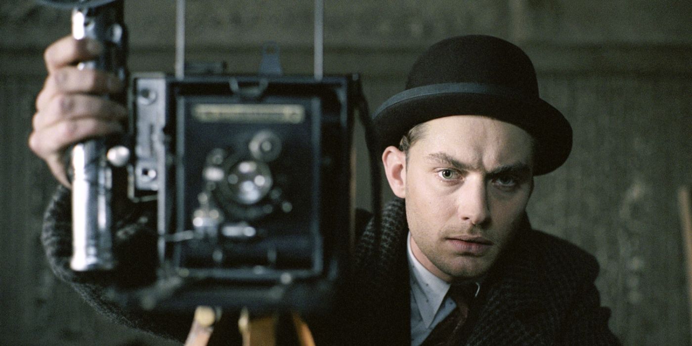 Harlen from Road to Perdition taking a photo on an old school camera