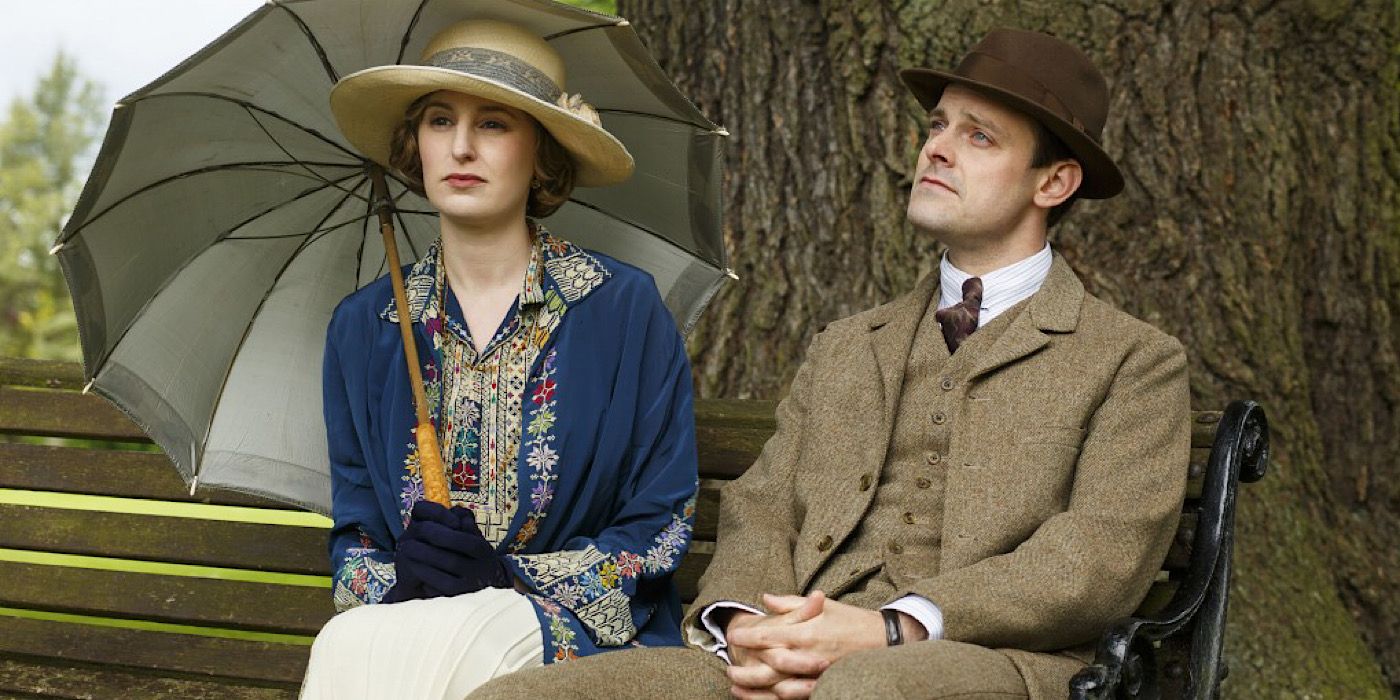 Edith has an umbrella open and sits on a bench next to Bertie in Downton Abbey.