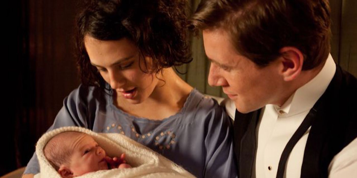 Sybil and Tom Branson holding their new child on Downton Abbey.