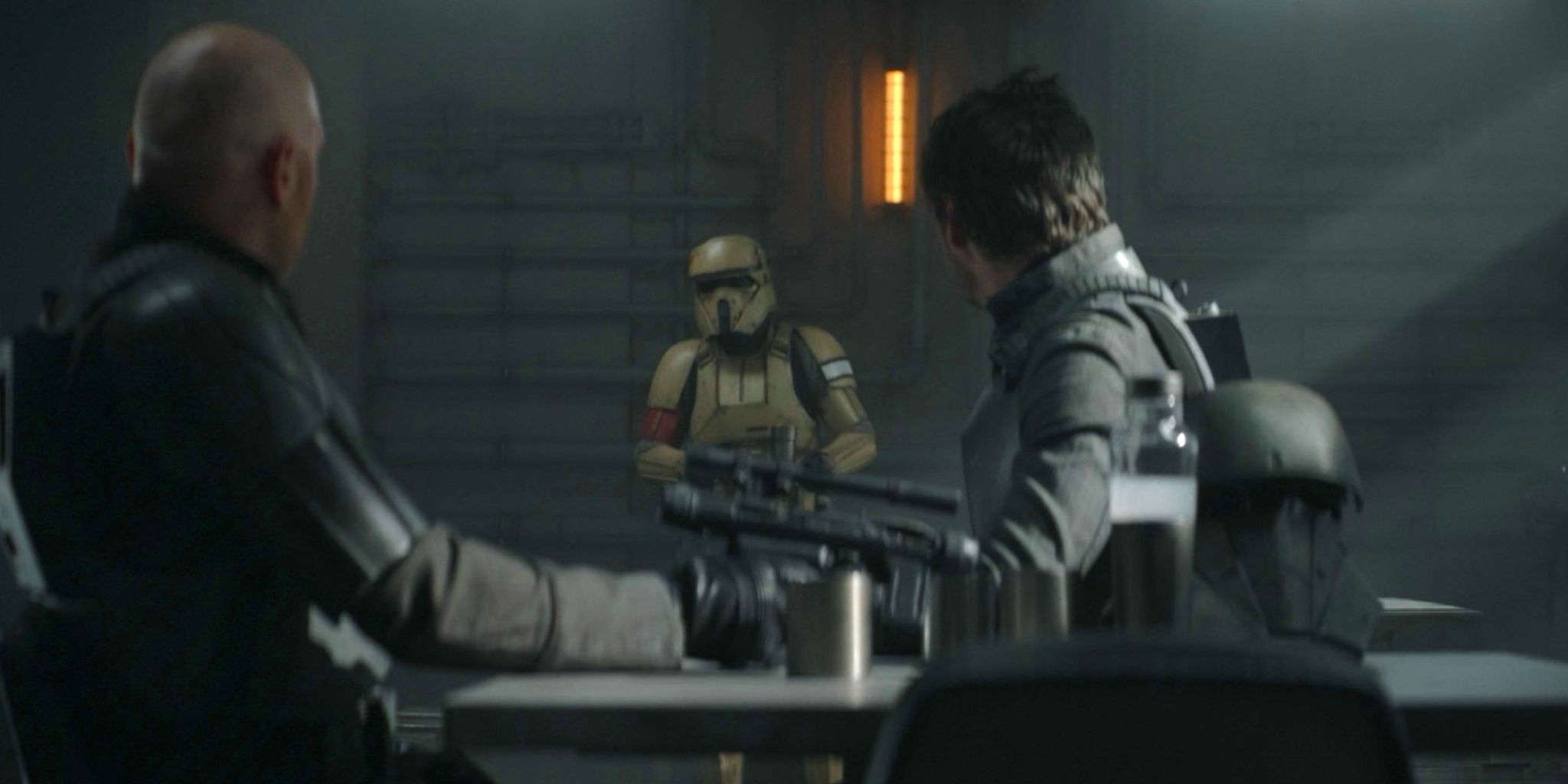 Bill Burr as Migs Mayfeld and Pedro Pascal as Din Djarn look at an Imperial scout trooper on Morak in The Mandalorian season 2 episode 7