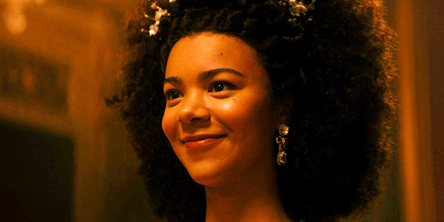 India Amarteifio as young Queen Charlotte smiling in Queen Charlotte episode 1