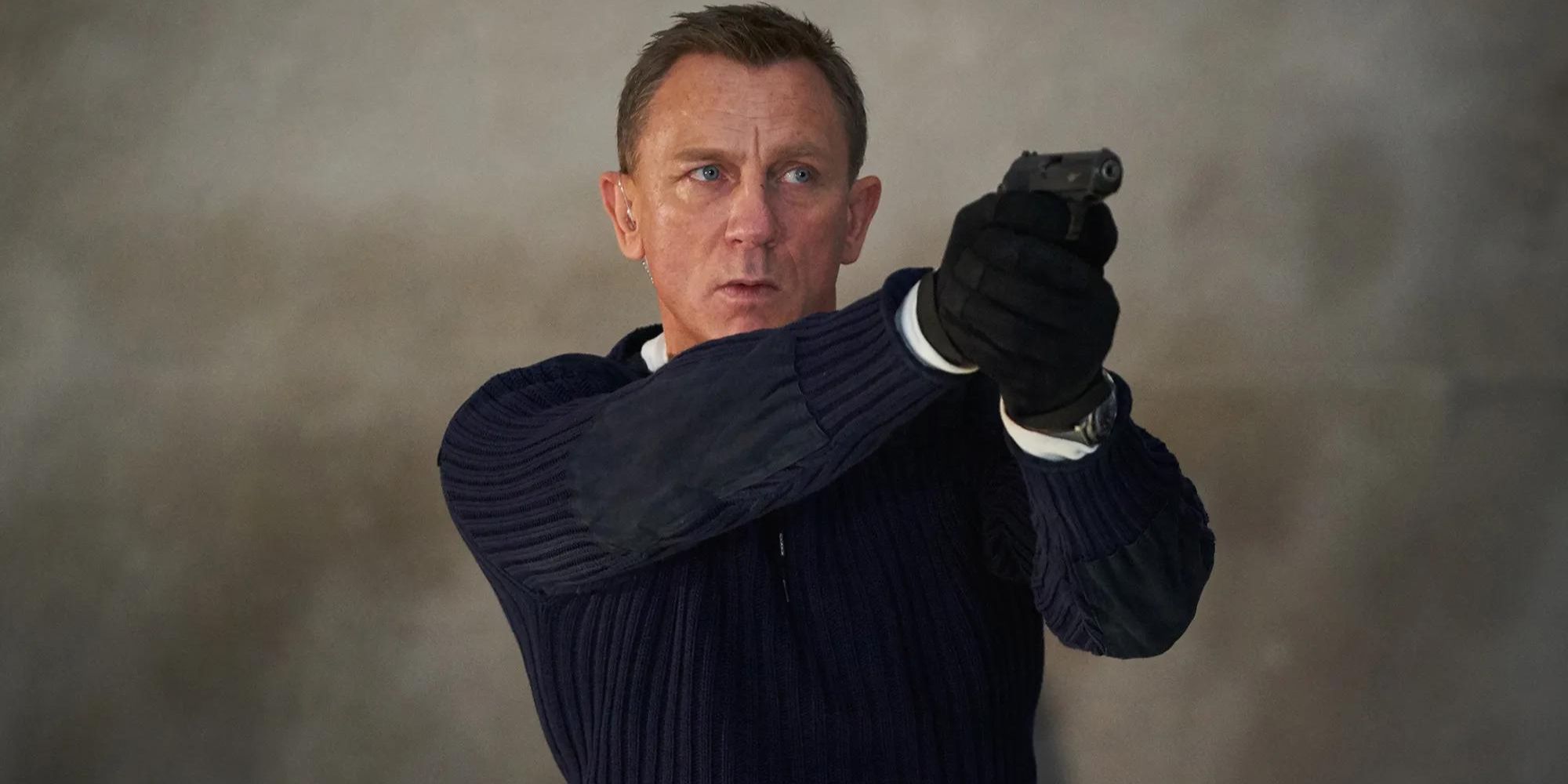 James Bond (Daniel Craig) points a pistol at an invisible enemy in No Time to Die