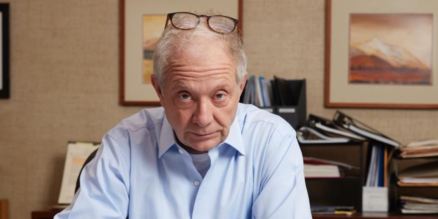 Jeff Perry as Stanley Kornik with glasses on his head, looking bemused in Alaska Daily