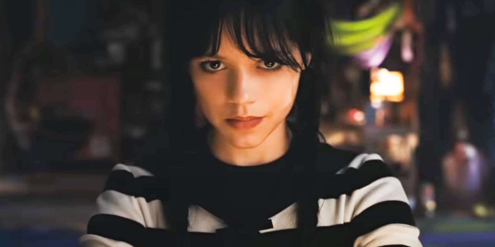Jenna Ortega as Wednesday Addams wearing a striped shirt and smirking