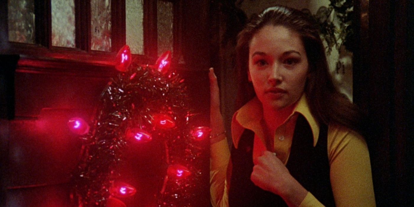 Jess standing in a doorway with a lit wreath in Black Christmas