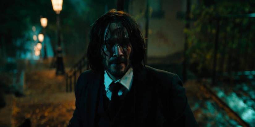 Keanu Reeves as a beaten John Wick looks up the stairs in John Wick: Chapter 4.
