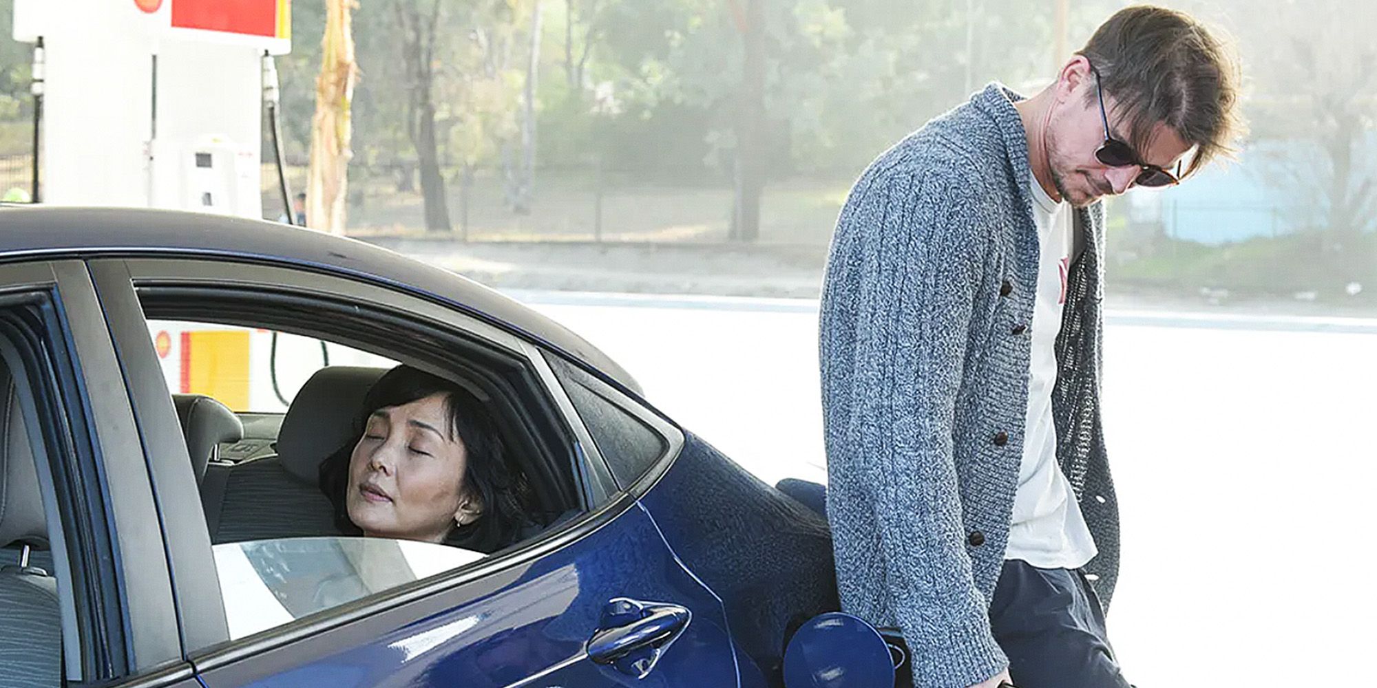 Josh Hartnett pumping gas while leaning on a car in Oh Lucy!