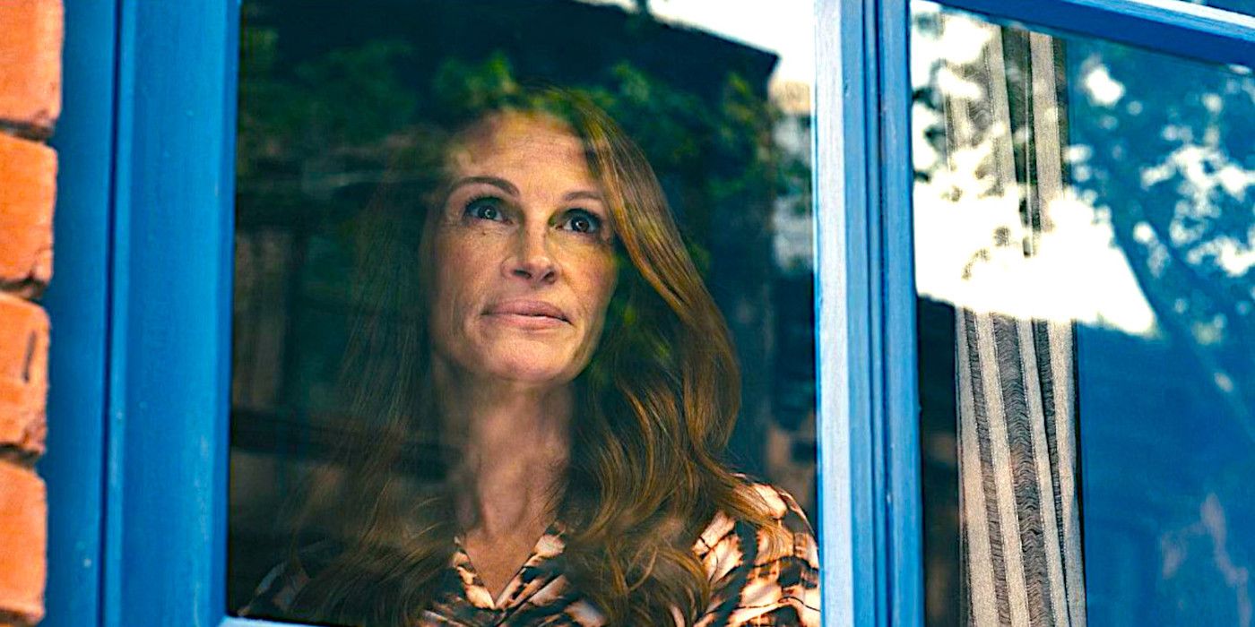 Julia Roberts as Amanda gazing out a window in a quiet scene from Leave the World Behind