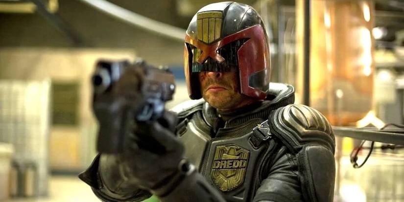 Karl Urban as Judge Dredd pointing his gun in Dredd