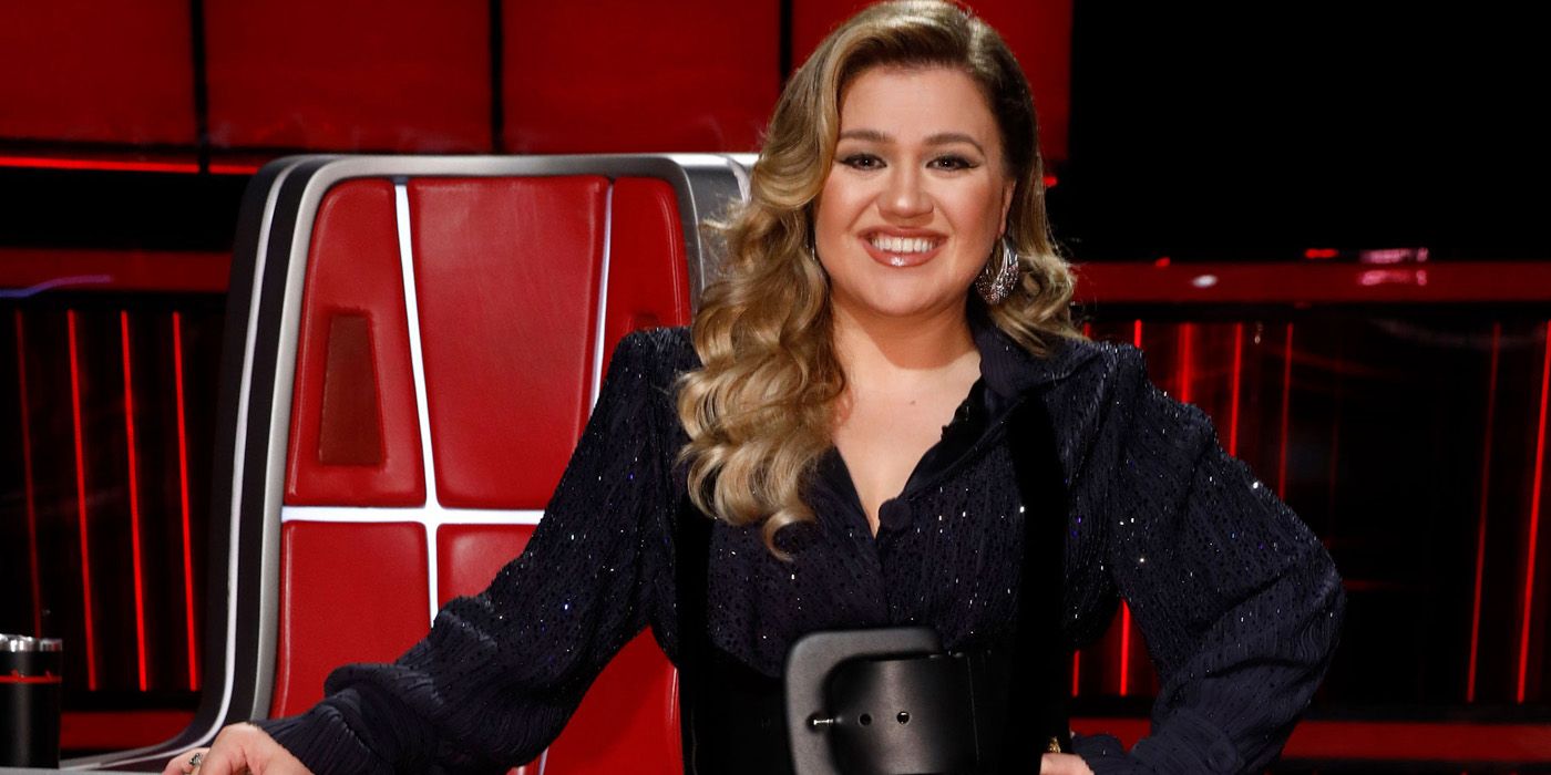 Kelly Clarkson standing by her chair on The Voice