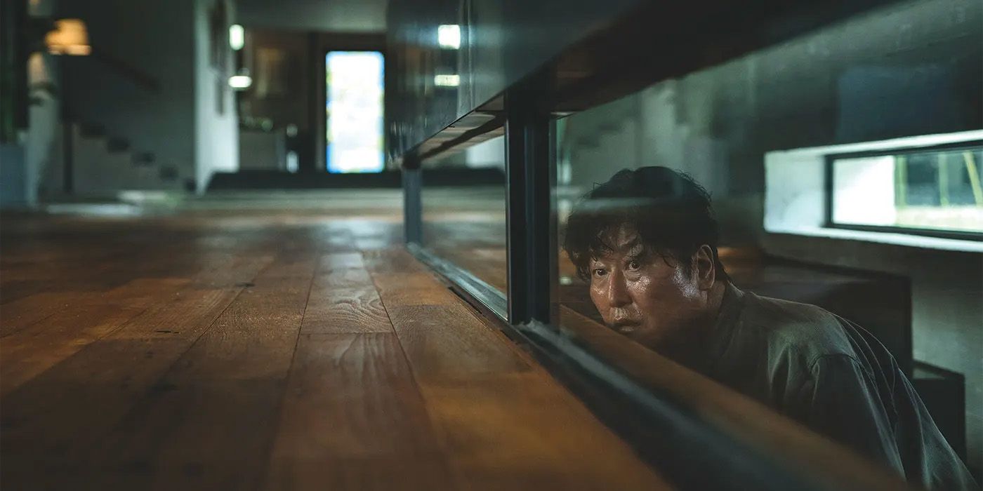 Song Kang-ho como Kim Ki-taek olhando por cima das escadas em Parasite