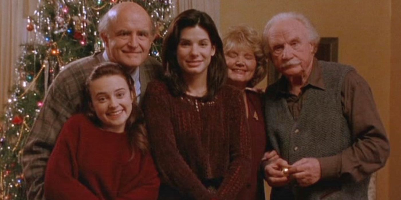 Lucy and the Callaghan family posing in front of a Christmas tree in While you were sleeping