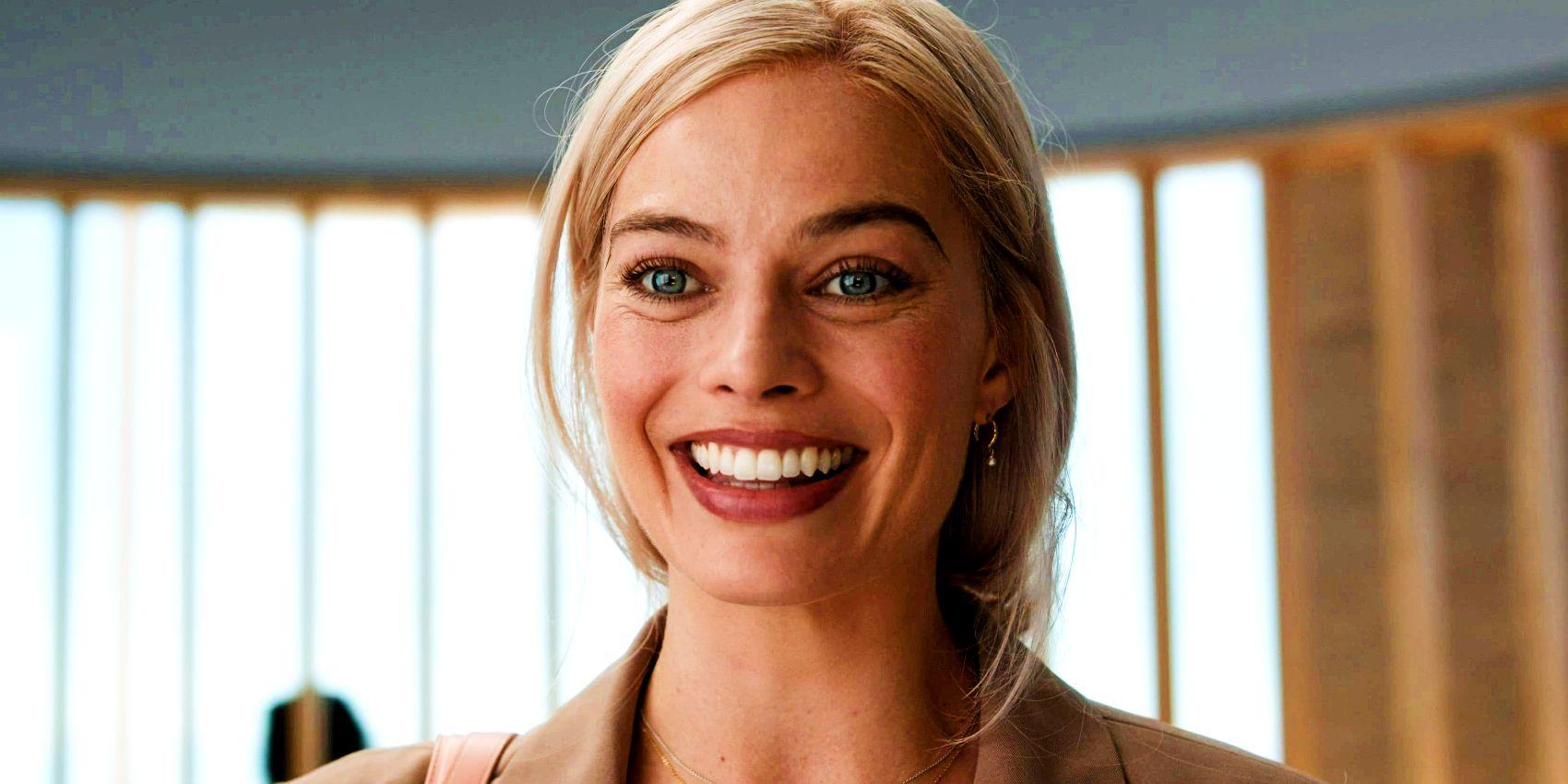 Margot Robbie as Stereotypical Barbie smiling in the doctor's office at the end of the Barbie movie.