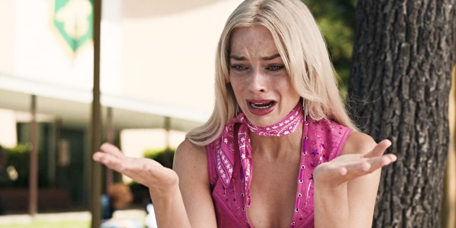 Barbie (Margot Robbie) crying with her arms up in disbelief in Barbie.