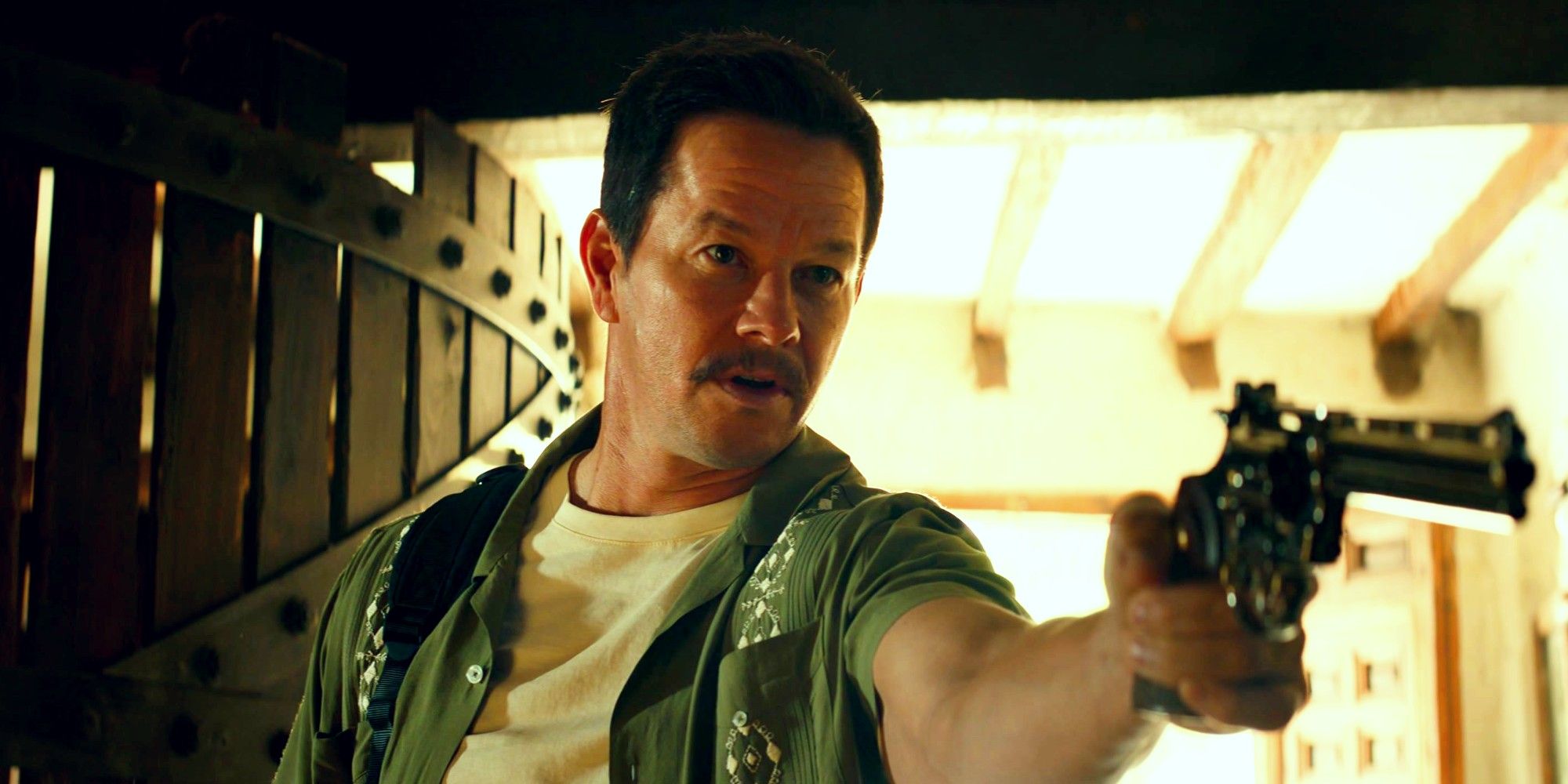 Mark Wahlberg como Victor Sullivan em Uncharted apontando uma pistola fora da tela