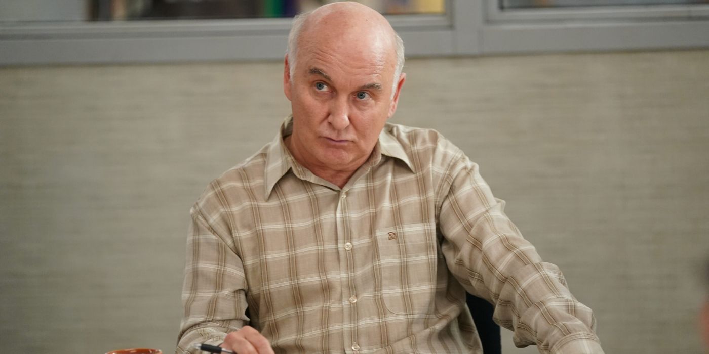 Matt Malloy as Bob Young sitting at a table giving the a side eye to something in Alaska Daily