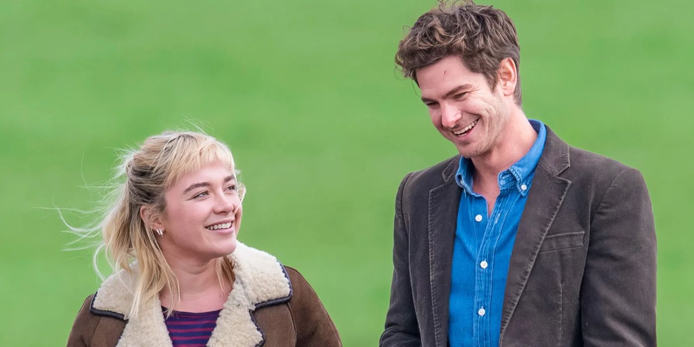 Florence Pugh and Andrew Garfield walking through a field in We Live in Time