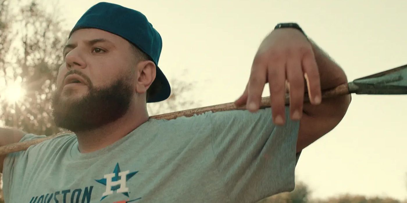 Mo hangs his arm on a baseball bat in the Netflix show Mo.