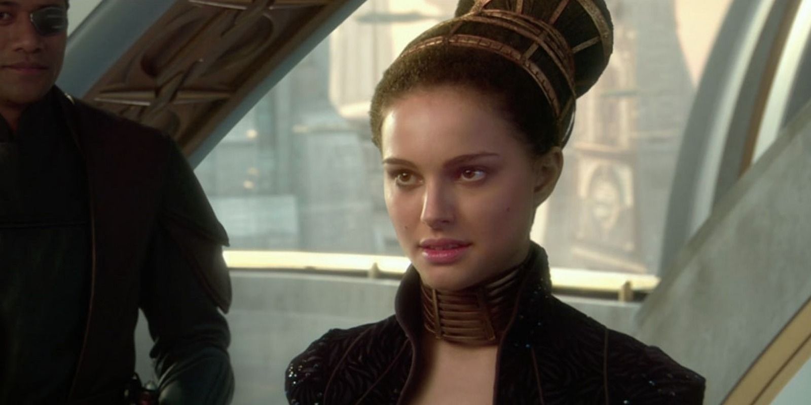 Padmé Amidala (Natalie Portman) in Star Wars Episode I: The Phantom Menace stands looking off-screen at someone.
