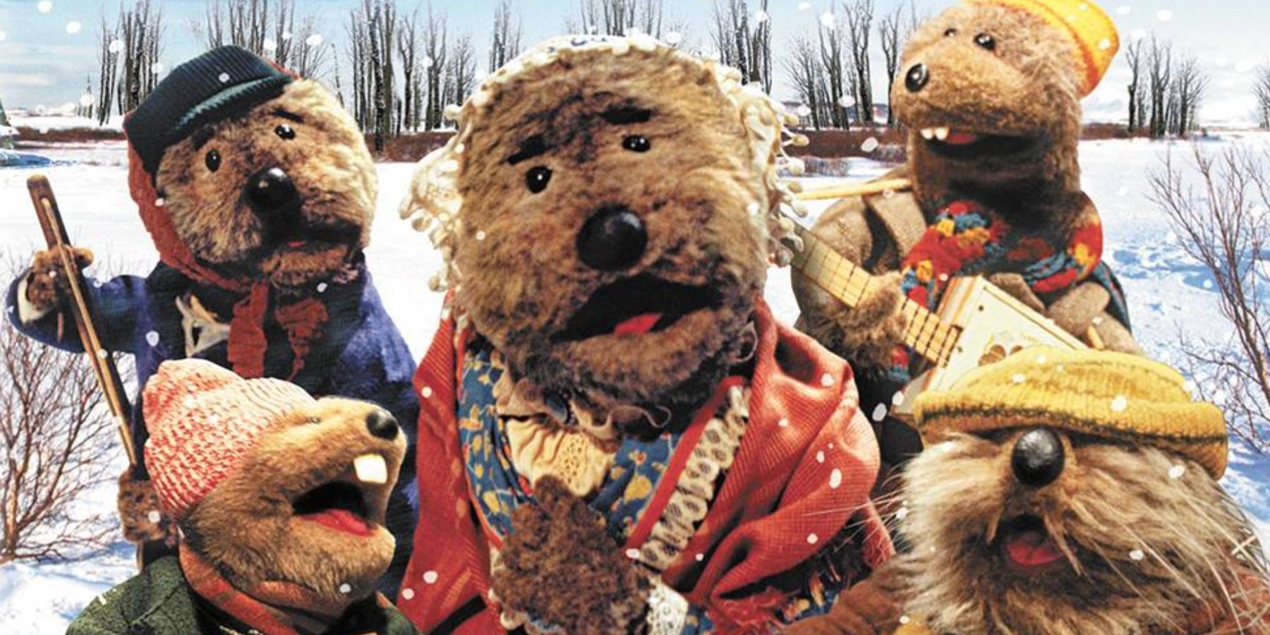 Otters created by the Jim Henson company hold instruments in the snow for Emmett Otters Jugband Christmas