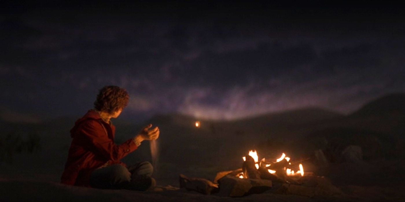 Percy Jackson sitting by the fire in a dream in episode 2