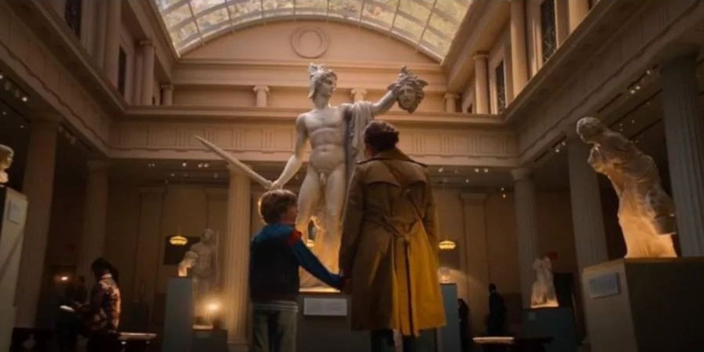 Azriel Dalman as young Percy Jackson and Virginia Kull as Sally Jackson standing in front of the Perseus statue in Percy Jackson & the Olympians