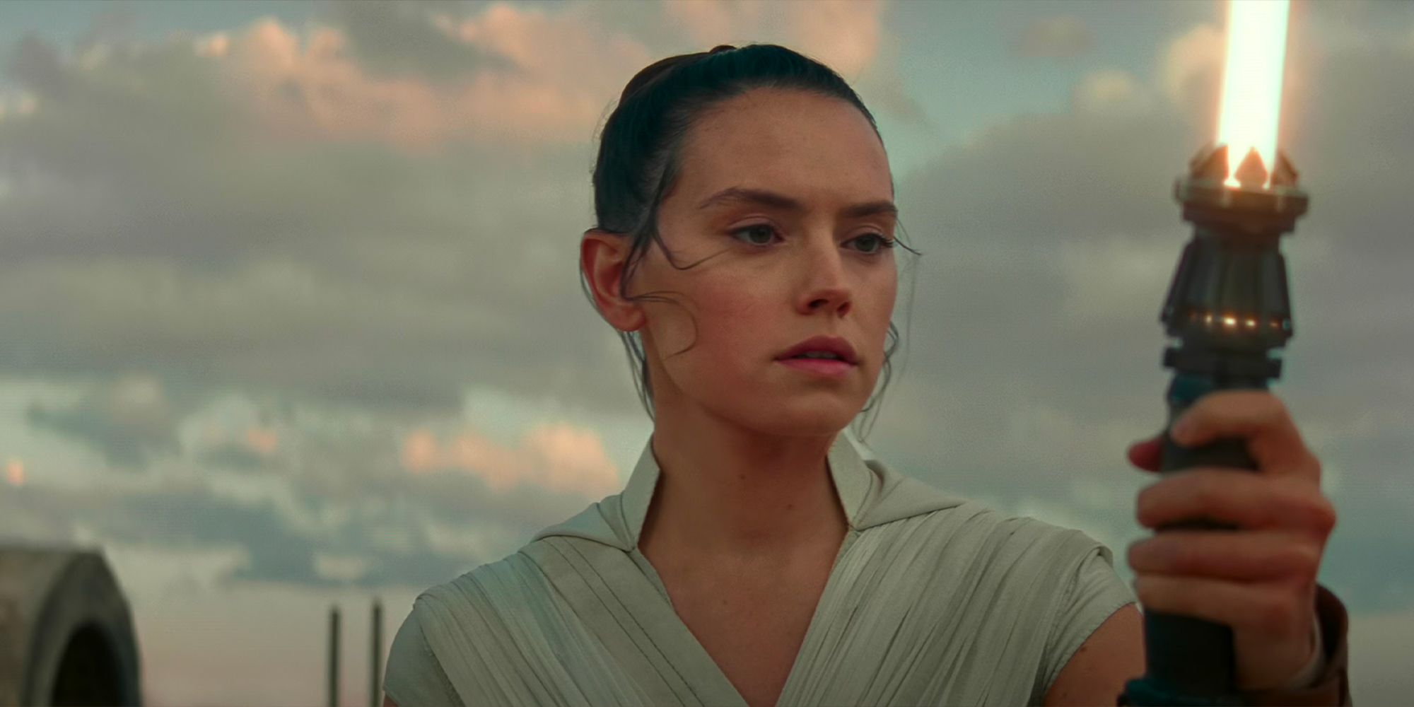 Rey using her yellow lightsaber on Tatooine