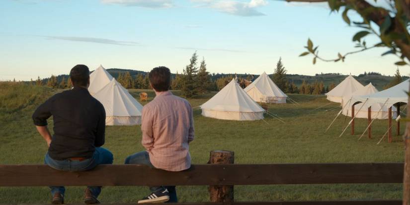 Richard and Will with their backs to the camera looking at the yurts and talking about turning the farm into a luxury getaway in My Life with the Walter Boys