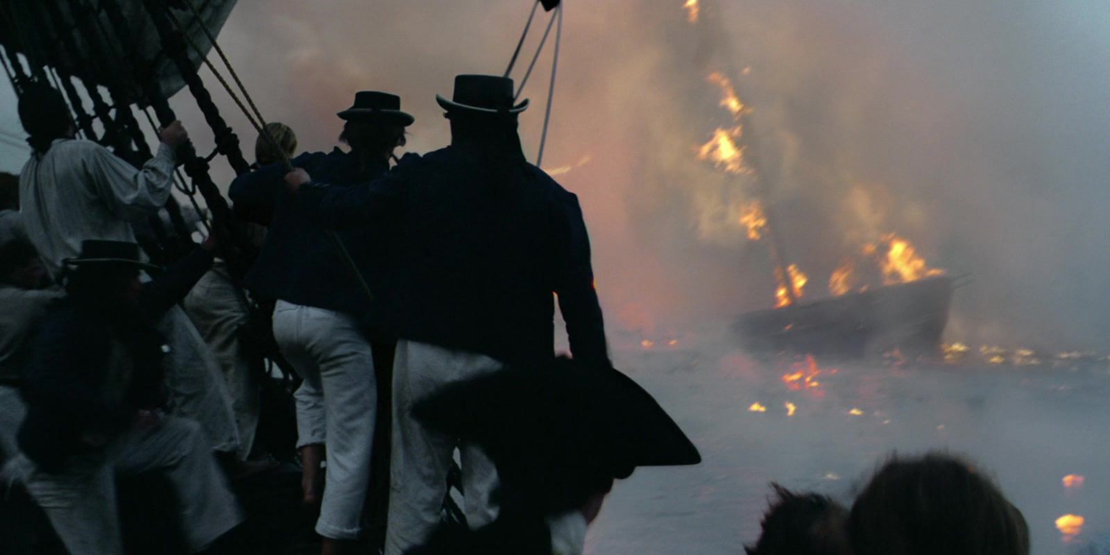 Sailors looking at a ship in flames in POTC Curse of the Black Pearl