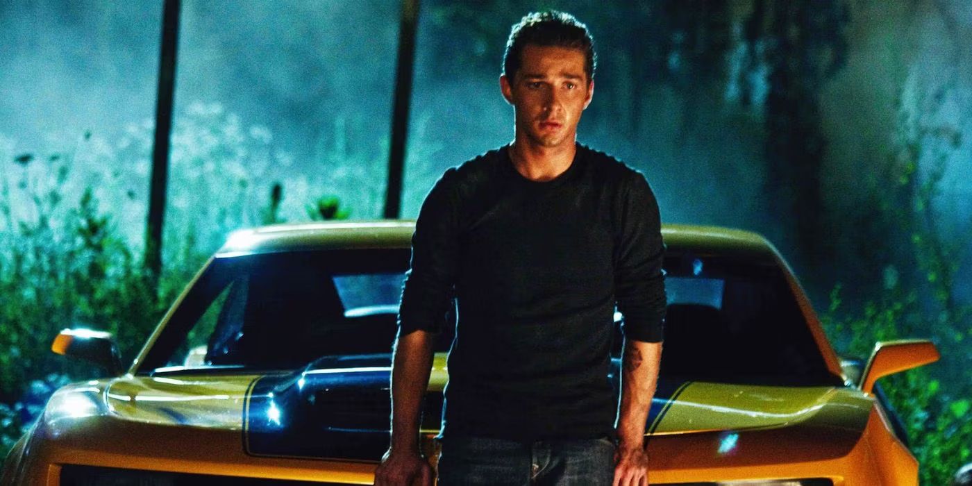 Sam (Shia Labeouf) stands in front of car form Bumblebee in Transformers.