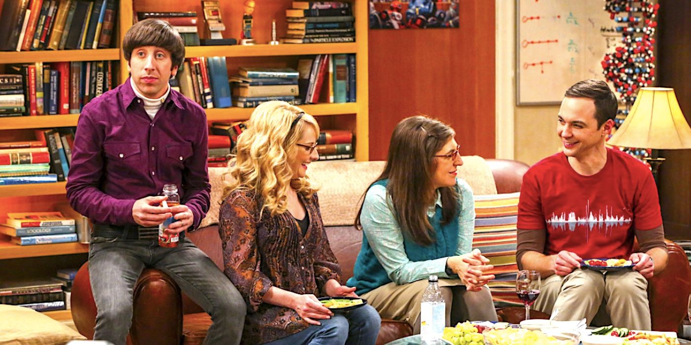 Simon Helberg's Howard, Melissa Rauch's Bernadette, Mayim Bialik's Amy, and Jim Parsons' Sheldon sit and talk on a couch in The Big Bang Theory %22The Holiday Summation%22