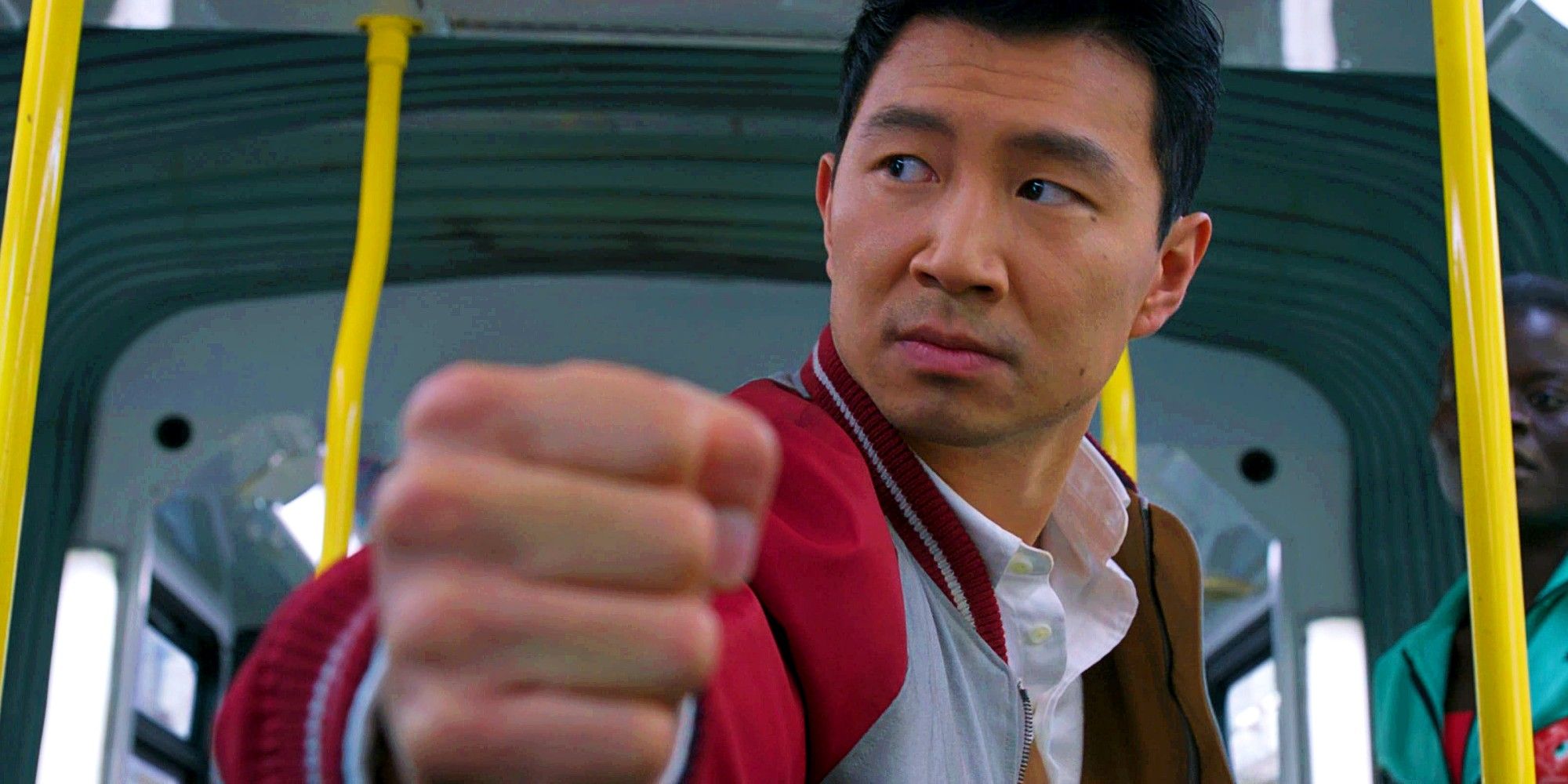 Simu Liu as Shang-Chi With His Fist To The Camera In the Middle Of A Fight On A Bus