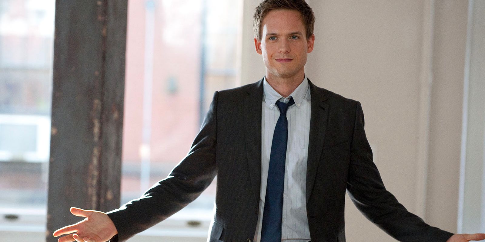 Patrick J. Adams' Mike Ross with arms extended as he stands in an office room in Suits