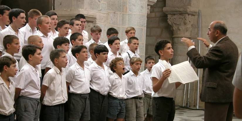 Gérard Jugnot as Clément Mathieu conducting students in the 2004 movie The Chorus (Les Choristes)