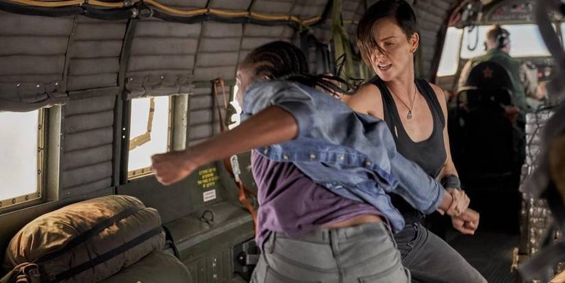 Andy (Charlize Theron) and Nile (KiKi Layne) fighting inside an airplane in The Old Guard 