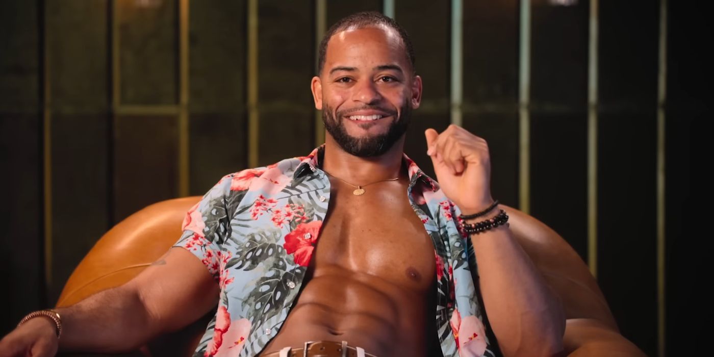 The Trust Season 1 police officer cast member sitting with his tropical print shirt unbuttoned