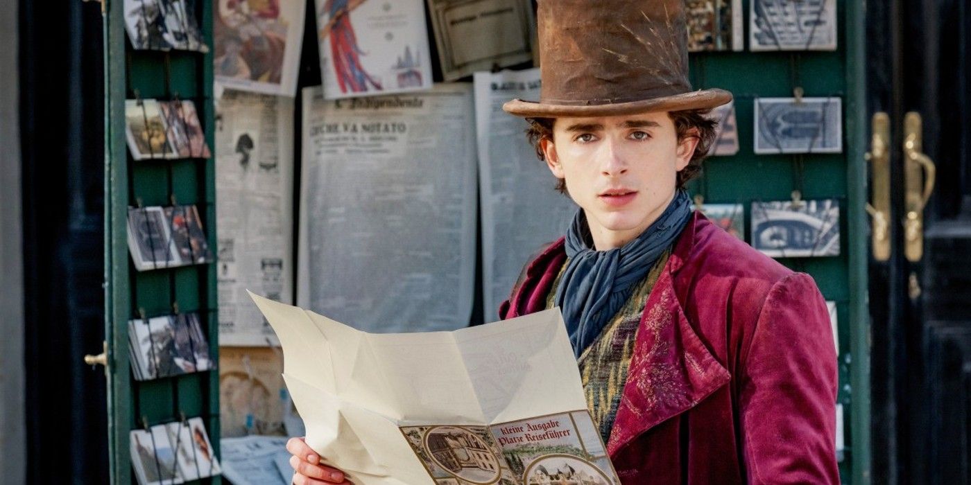Timothee Chalamet as Willy Wonka reading a large map in Wonka