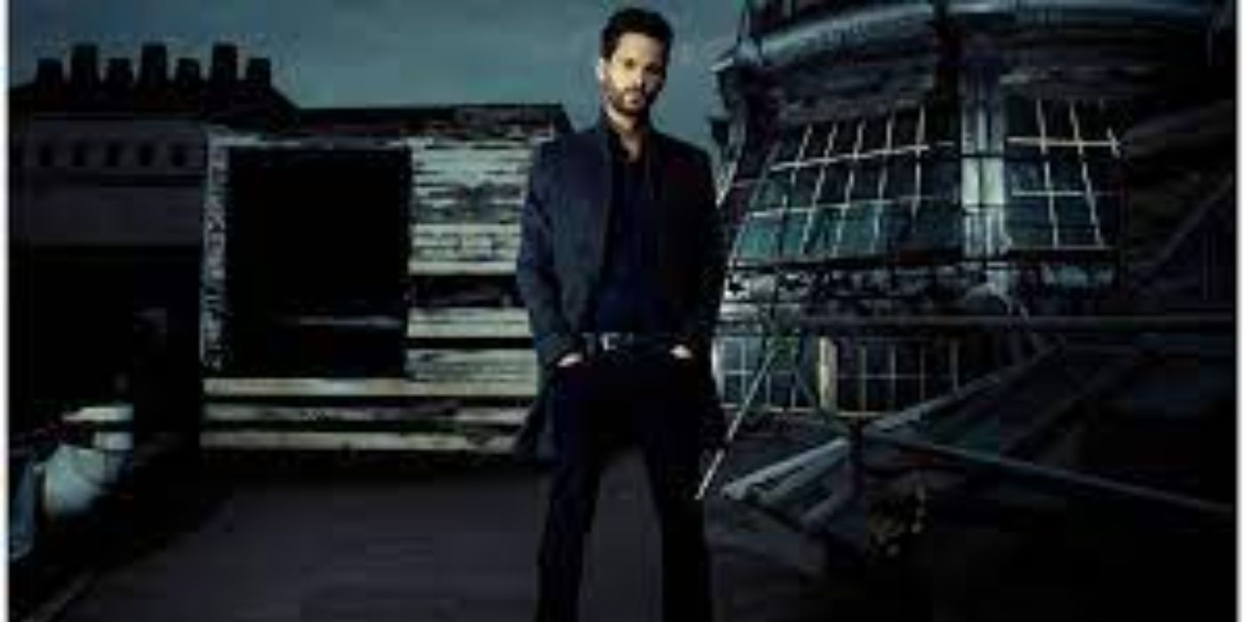 Tom Riley as Staffe standing in front of a cityscape in Dark Heart.