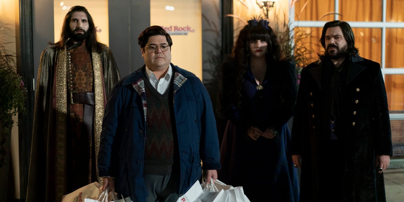 Guillermo carrying shopping bags with Nandor, Nadja, and Laszlo stood behind him in What We Do in the Shadows