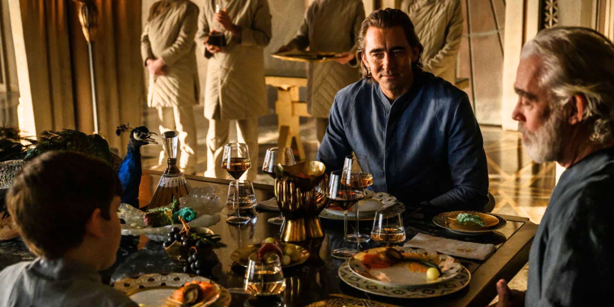 Lee Pace as Brother Day in Foundation, sitting at a table with the other Cleon clones