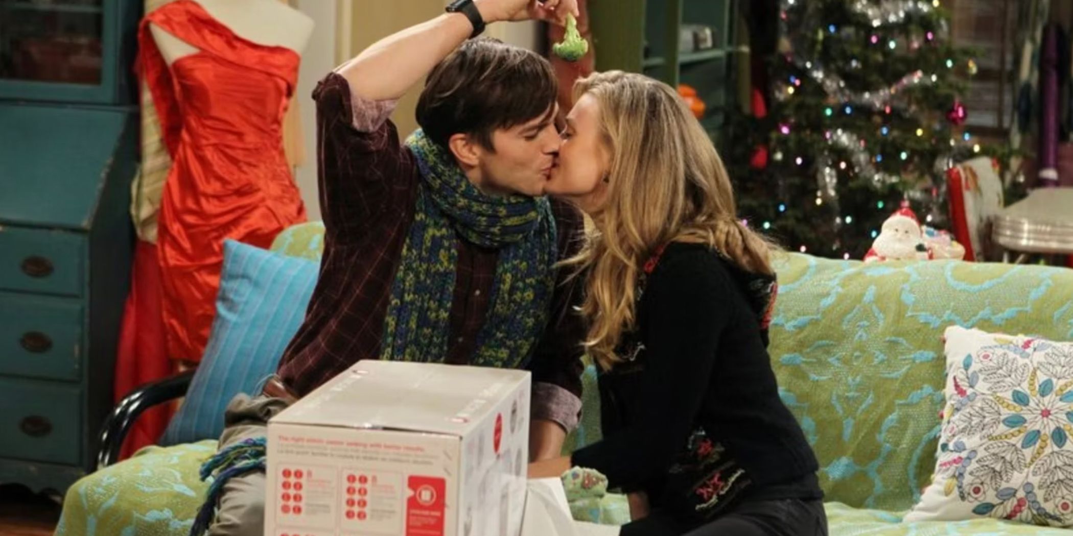 Walden holding broccoli over his head as a woman kisses him in the Two and a Half Men episode Give Santa A Tail Hole
