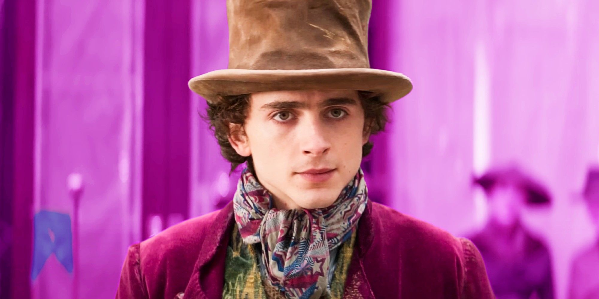 Timothée Chalamet as Willy Wonka in the Wonka movie with a pink background