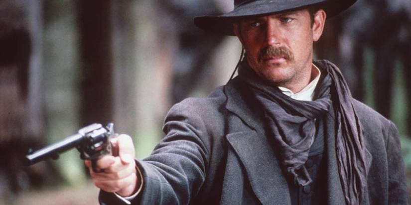 Kevin Costner as Wyatt Earp pointing a pistol in Wyatt Earp