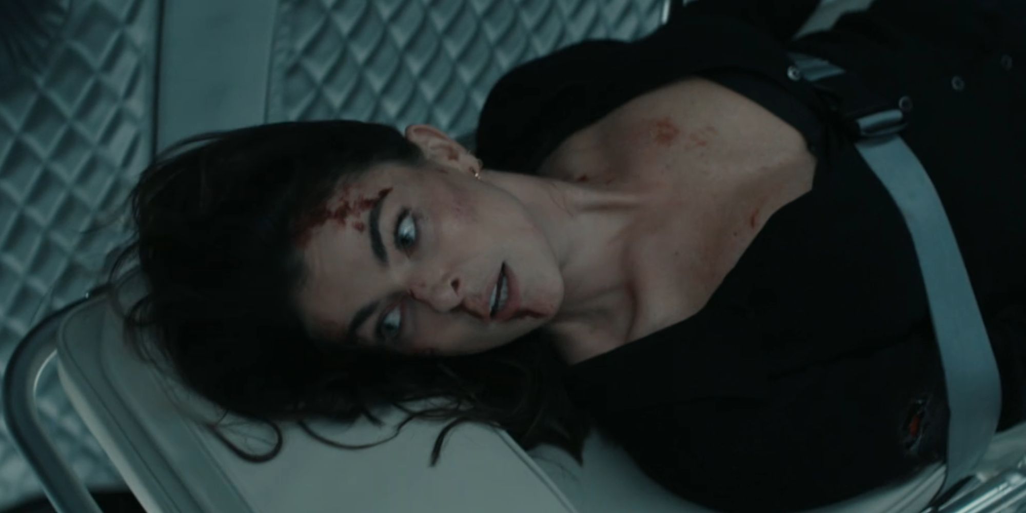 Serinda Swan as Karla Dixon tied to a stretcher and looking scared in Reacher