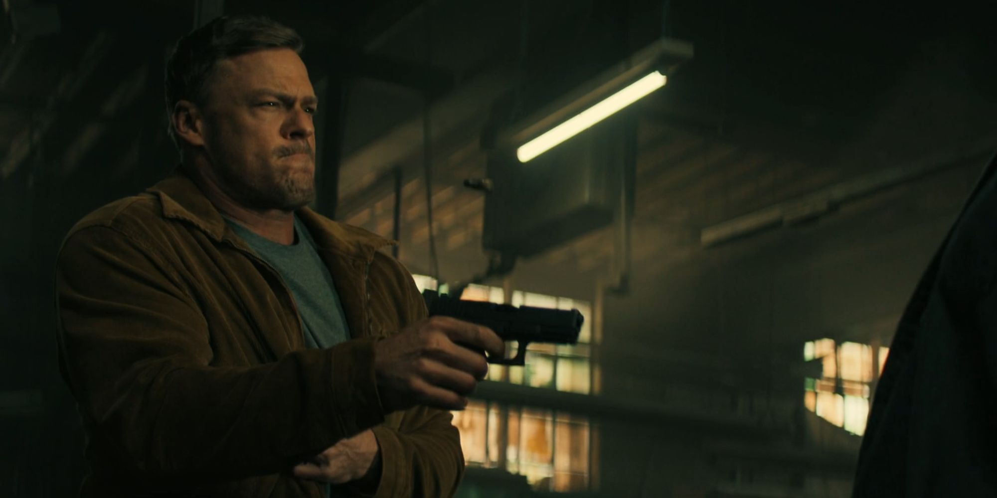 Alan Ritchson as Reacher shooting someone