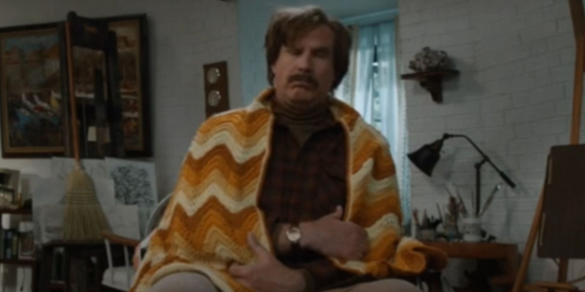 Will Ferrell as Rob Burgundy sitting with a blanket around him in Anchorman 2