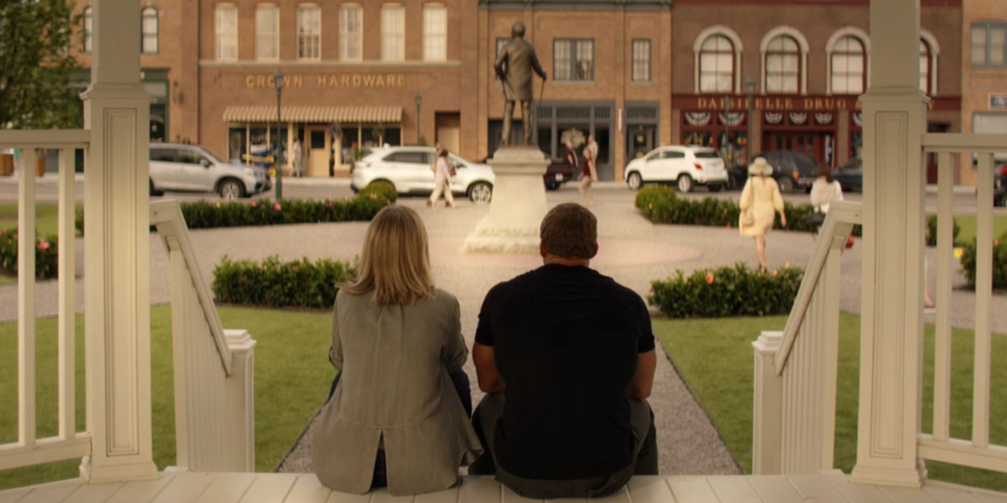 Alan Ritchson as Reacher and Willa Fitzgerald as Roscoe Conklin sitting next to each other from behind.