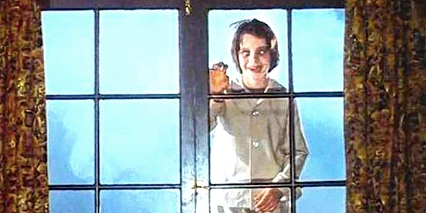 A vampire child taps on the window while smiling in Salem's Lot 1978