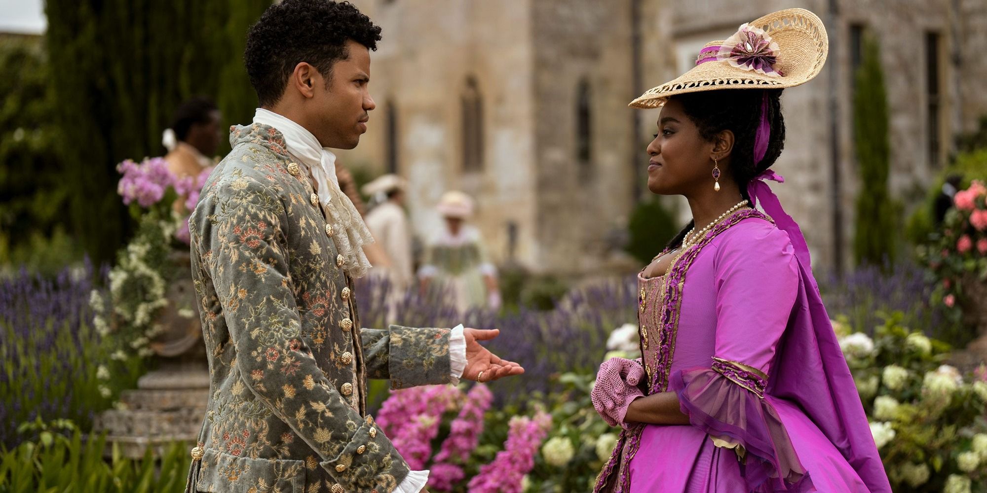 Tunji Kasim as Adolphus stands with Arsema Thomas as Agatha Danbury in Queen Charlotte: A Bridgerton Story