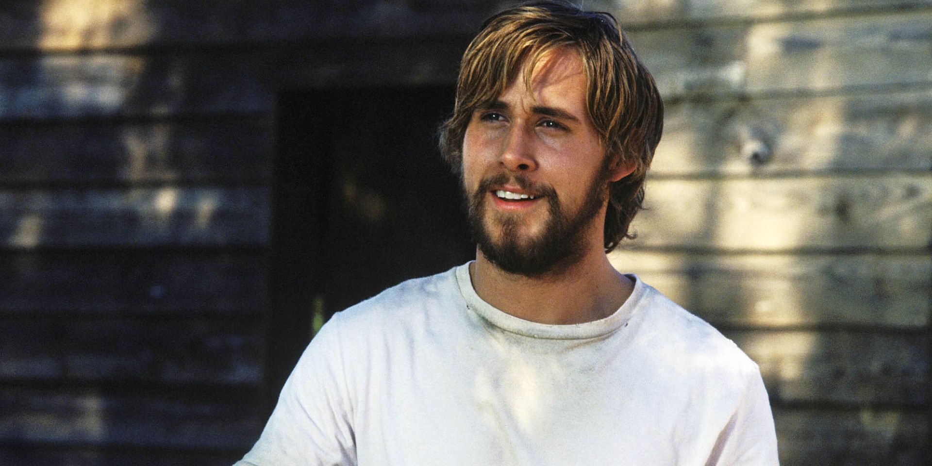 Noah Calhoun (Ryan Gosling) smiling with long hair and a beard in The Notebook.